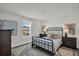 Cozy bedroom with an iron bed frame, neutral decor, and wood-look flooring at 7959 Chandler Lake Ct, Hudson, FL 34667