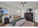 Inviting bedroom with ample natural light, ceiling fan, and serene views at 7959 Chandler Lake Ct, Hudson, FL 34667