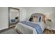A cozy bedroom showcasing a large framed mirror, plush bedding, and neutral tones at 7959 Chandler Lake Ct, Hudson, FL 34667