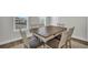Bright dining room with a large wood table and six chairs under natural light from the windows at 7959 Chandler Lake Ct, Hudson, FL 34667