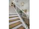 Stylish staircase featuring wooden steps, black metal railings, and elegant decor at 7959 Chandler Lake Ct, Hudson, FL 34667