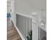 View of a staircase with white posts, black railings and hard surface flooring at 7959 Chandler Lake Ct, Hudson, FL 34667
