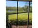A well-maintained dock and waterway with tropical foliage viewed through a screened-in patio at 8744 54Th W Ave # 8744, Bradenton, FL 34210