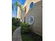 A charming condo exterior showcases unique round windows, complemented by lush landscaping and a sidewalk at 8744 54Th W Ave # 8744, Bradenton, FL 34210