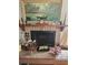 Close-up of a brick fireplace, decorated mantel with artwork and decorative elements at 8744 54Th W Ave # 8744, Bradenton, FL 34210