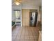 Open floor plan kitchen features tile flooring, ceiling fan, stainless steel refrigerator and a breakfast nook with unique circular window at 8744 54Th W Ave # 8744, Bradenton, FL 34210