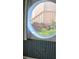 A close-up of a unique round window with tropical foliage and striped wallpaper at 8744 54Th W Ave # 8744, Bradenton, FL 34210