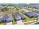 Aerial view of a home with a pond, manicured lawn and a three-car garage at 11820 Stone Pine St, Riverview, FL 33569
