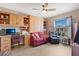 Comfortable living room featuring a built-in desk, cabinets, hardwood floors and a ceiling fan at 11820 Stone Pine St, Riverview, FL 33569