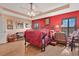 Spacious main bedroom with red accent wall, and traditional furnishings at 11820 Stone Pine St, Riverview, FL 33569