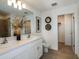 Bright bathroom with double sinks, white cabinets and granite countertops, with tile flooring at 1755 Spreader Ln, Sarasota, FL 34240