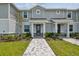 Charming townhouse exterior with gray siding, stone accents, and a well-manicured front yard at 1755 Spreader Ln, Sarasota, FL 34240