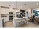 Modern kitchen with white cabinets, stainless steel appliances, island with seating, and adjacent dining area at 1755 Spreader Ln, Sarasota, FL 34240