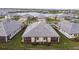 An aerial view of new homes with gray roofs, manicured lawns and a peaceful lake nearby at 18032 Cherished Loop, Bradenton, FL 34211