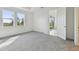 Well-lit bedroom featuring neutral carpet, two windows, and open doorway at 18032 Cherished Loop, Bradenton, FL 34211
