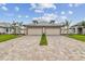 Symmetrical home exterior featuring two-car garages, brick driveways and perfectly manicured lawns and landscaping at 18032 Cherished Loop, Bradenton, FL 34211