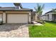 A lovely home featuring an attached two-car garage with a brick-paved driveway and a manicured lawn at 18032 Cherished Loop, Bradenton, FL 34211
