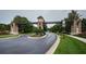 Welcoming community entrance featuring stone pillars, a clock tower, and beautifully maintained landscaping at 3033 Stonegate Falls Dr, Land O Lakes, FL 34638