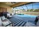 The screened-in pool area offers lounge seating, a grill, and a beautiful waterfront view at 3033 Stonegate Falls Dr, Land O Lakes, FL 34638