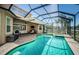 Backyard pool and patio with screen enclosure, covered seating area, and water view at 3033 Stonegate Falls Dr, Land O Lakes, FL 34638