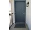 Close-up of a stylish steel front door with dark trim and a 'Welcome' mat, illuminated by a wall-mounted lantern at 3102 W Horatio St # 21, Tampa, FL 33609