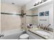 Bathroom featuring a combination tub and shower, marble tiling, granite vanity, and decorative mirror at 3703 Cooper Rd, Plant City, FL 33565