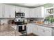 Modern kitchen featuring stainless steel appliances, white cabinets, and granite countertops at 3703 Cooper Rd, Plant City, FL 33565
