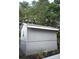 Side view of a gray wood shed with a small window and landscaping at 3703 Cooper Rd, Plant City, FL 33565