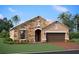 Charming one-story home featuring a stone facade, arched entryway, and well-manicured lawn at 17208 Savory Mist Cir, Bradenton, FL 34211