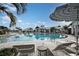 A large community pool with lounge chairs and palm trees creating a relaxing and inviting atmosphere at 17212 Savory Mist Cir, Lakewood Ranch, FL 34211