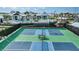 Aerial view of tennis courts and a community pool surrounded by palm trees and ample seating at 17212 Savory Mist Cir, Lakewood Ranch, FL 34211