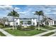 A welcoming clubhouse entrance with palm trees, lush landscaping, and ample parking at 17216 Savory Mist Cir, Bradenton, FL 34211
