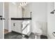 This bathroom features black hexagon floor tiles, white cabinets, a black countertop, and modern fixtures at 17245 Savory Mist Cir, Bradenton, FL 34211