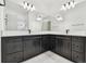 Bathroom with double vanity, dark cabinets, light countertop, and framed mirrors at 17245 Savory Mist Cir, Bradenton, FL 34211
