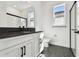 This bathroom has a glass shower, white cabinets, a black countertop, black hexagon floor tiles, and modern black fixtures at 17245 Savory Mist Cir, Bradenton, FL 34211