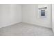 A bright bedroom featuring neutral carpeting, white walls and trim, and a window providing ample natural light at 17245 Savory Mist Cir, Bradenton, FL 34211