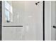 This bathroom has a glass door shower with white tile surround and modern black hardware at 17245 Savory Mist Cir, Bradenton, FL 34211