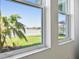 Window view of a lake, palm trees, community homes, and blue skies at 17245 Savory Mist Cir, Bradenton, FL 34211