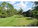 Expansive backyard featuring a lush green lawn and tall trees, providing privacy and a natural setting at 2735 Lavandula Ct, North Port, FL 34289