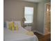 Comfortable bedroom with a plush white bed and bright yellow accent pillows and adjoining bathroom at 2735 Lavandula Ct, North Port, FL 34289