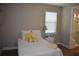 Cozy bedroom featuring a plush bed with yellow accents, a window for natural light, and an ensuite bathroom at 2735 Lavandula Ct, North Port, FL 34289