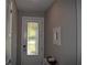 Bright foyer with a decorative glass door, neutral paint, and a small table with decorative items at 2735 Lavandula Ct, North Port, FL 34289