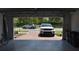 View from inside a two-car garage with an open garage door showing brick pavers and two parked cars at 2735 Lavandula Ct, North Port, FL 34289