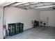 Spacious garage featuring white walls, concrete floor and three black waste cans at 2735 Lavandula Ct, North Port, FL 34289