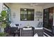 Charming covered patio area with brick flooring, ceiling fan, and comfortable wicker seating arrangement at 2735 Lavandula Ct, North Port, FL 34289