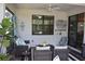 Charming covered patio area with brick flooring, ceiling fan, and comfortable wicker seating arrangement at 2735 Lavandula Ct, North Port, FL 34289