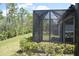 Relaxing screened patio with view of landscaping, beautiful trees and partial view of house at 2735 Lavandula Ct, North Port, FL 34289