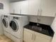 Convenient laundry room with washer, dryer, white cabinets, and black countertops for efficient chores at 3060 Grand Bay Blvd # 174, Longboat Key, FL 34228