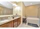 Bathroom with double sinks, a soaking tub, a glass-enclosed shower, and granite countertops at 4604 W Fig St # 1, Tampa, FL 33609