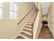 Bright staircase with hardwood steps and a white banister, leading to the upper level at 4604 W Fig St # 1, Tampa, FL 33609